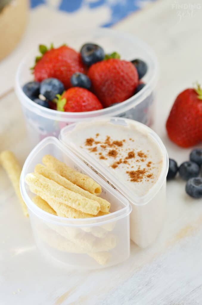yogurt dip with berries and apple straws on the side.
