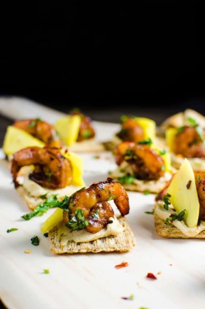 mini triscuit topped finger food with shrimp and mango