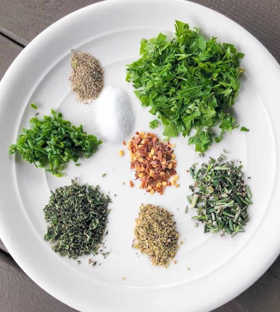Herbs for bread dipping oil on a plate.