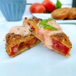 a fried red tomato with aioli sauce over top