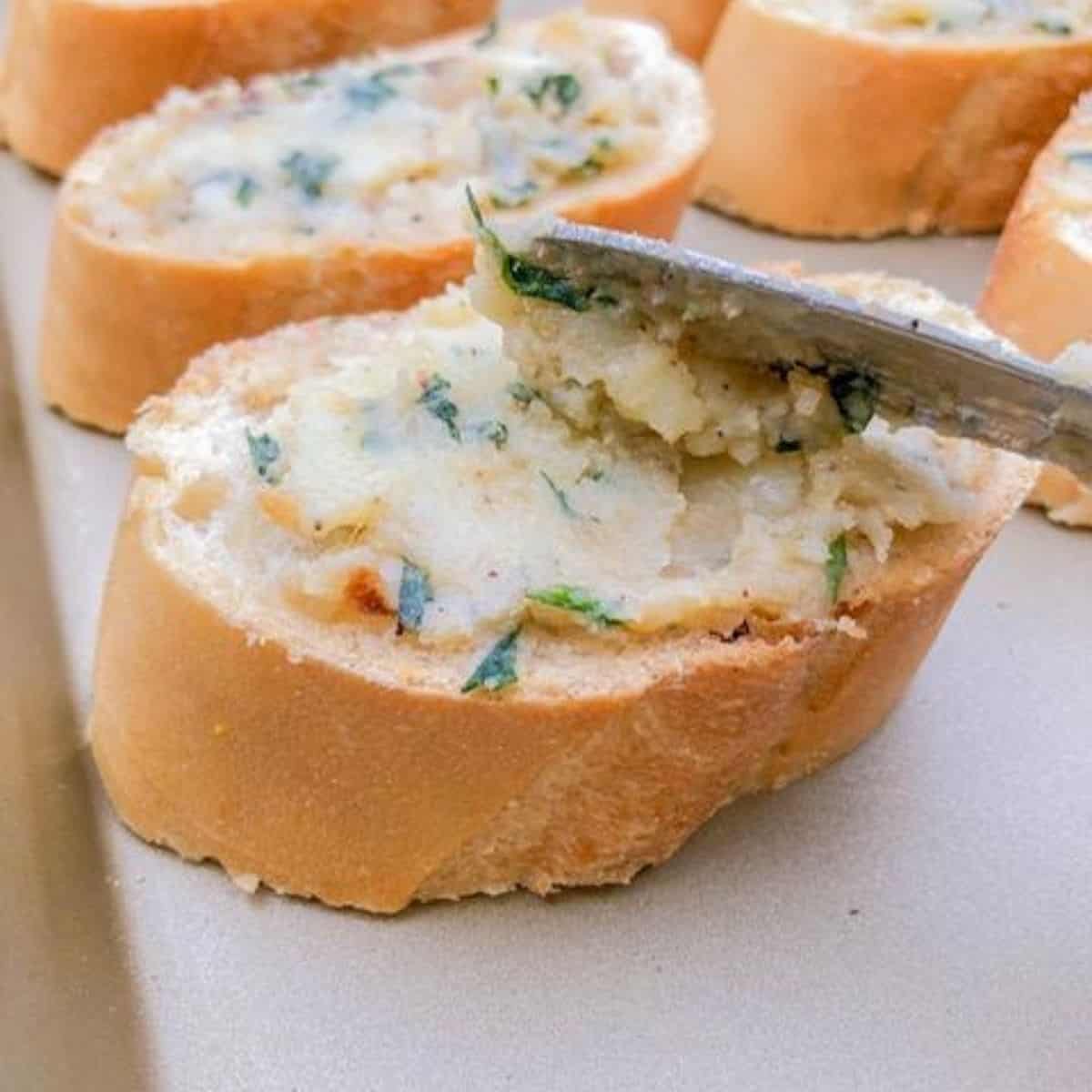 Spreading garlic butter onto bread.