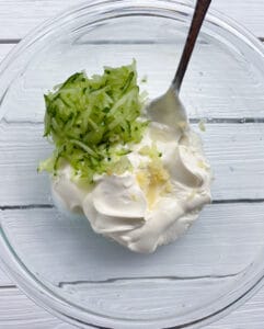 Sour cream and cucumber in a bowl.
