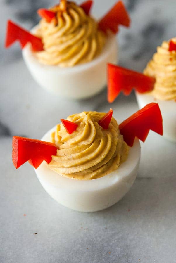 Halloween deviled eggs with devil ears and wings made from peppers.