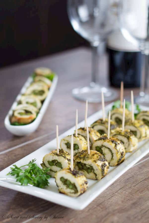 pesto chicken skewers on a white plate served with toothpick skewers.