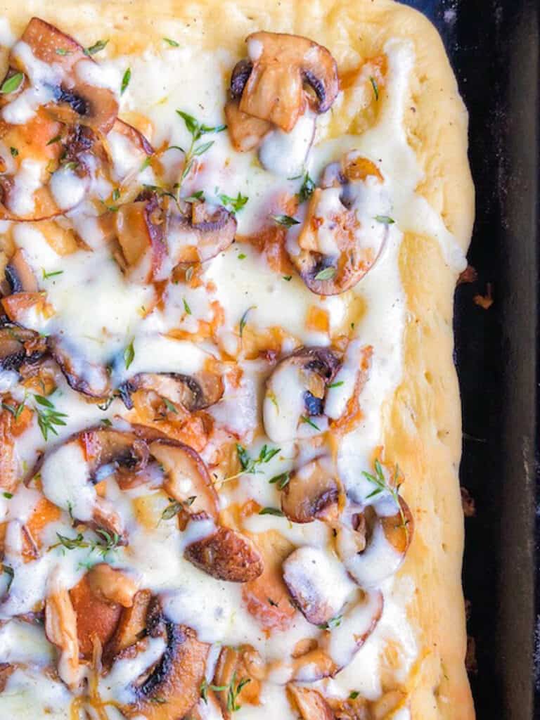 baked mushroom and onion flatbread on a baking sheet