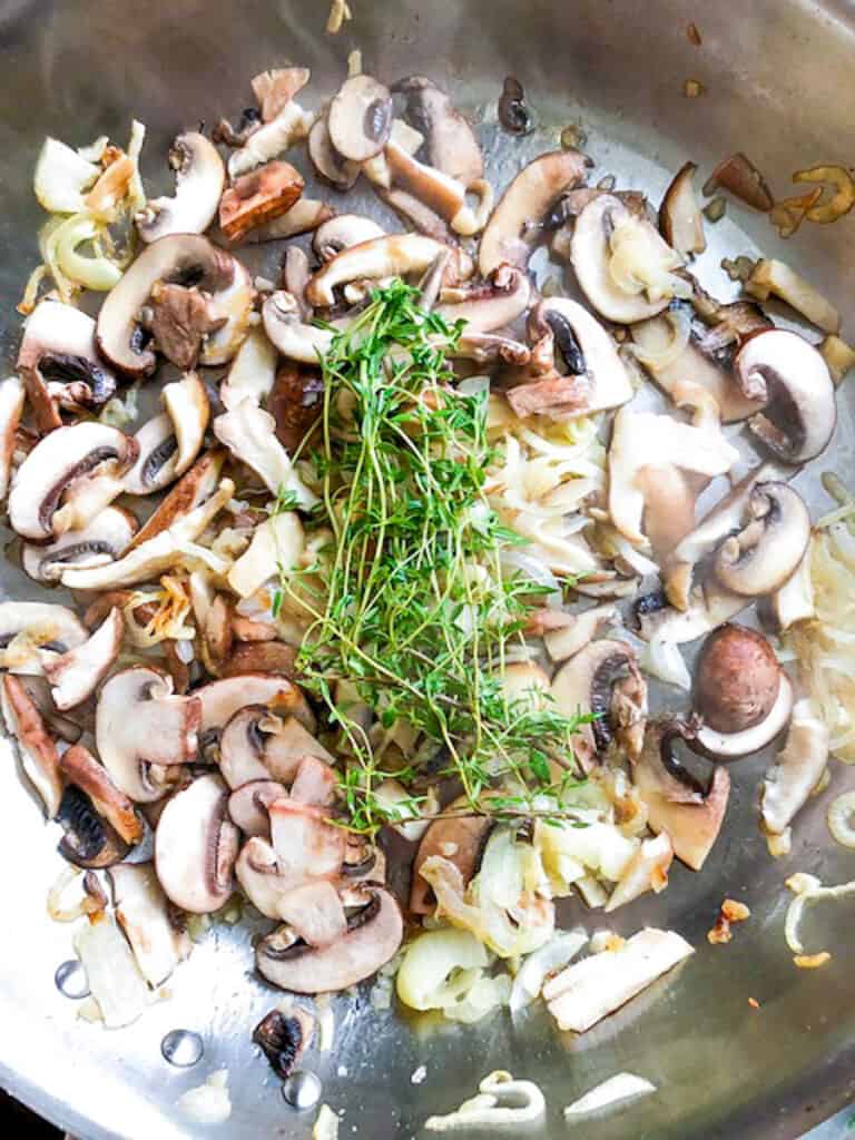 mushrooms, onions, thyme in a skillet