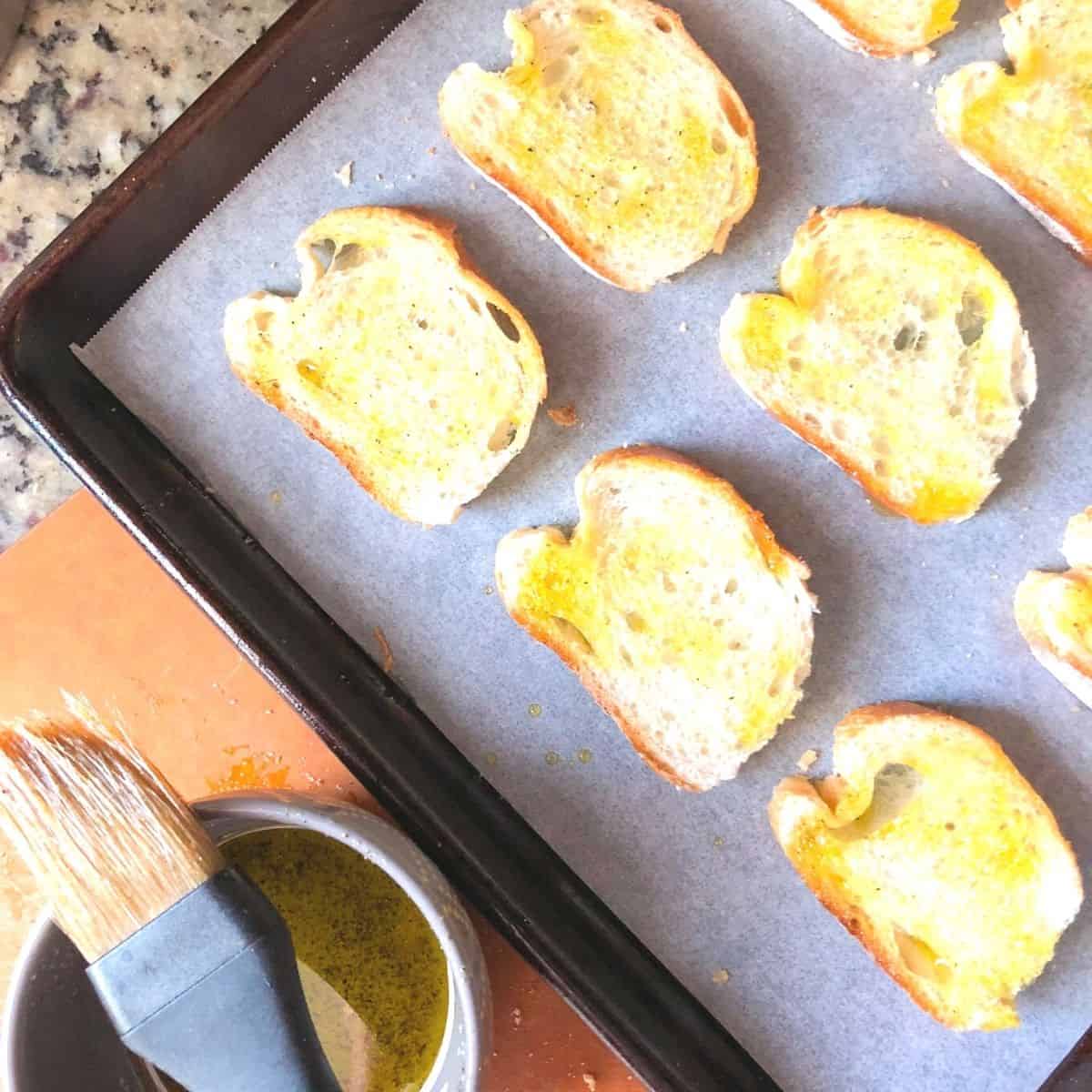 brushing crostini with extra virgin olive oil.