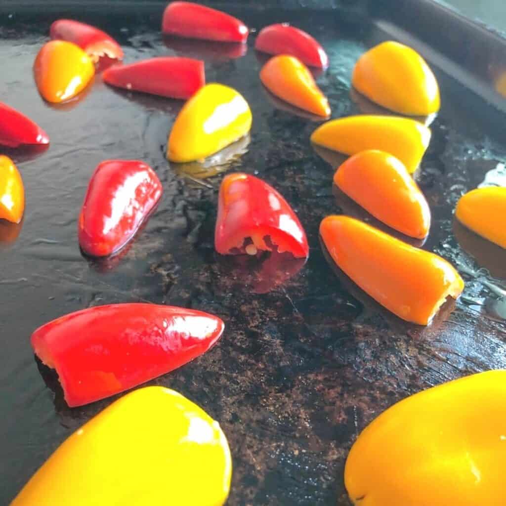 baby bell peppers cut on sheet pan