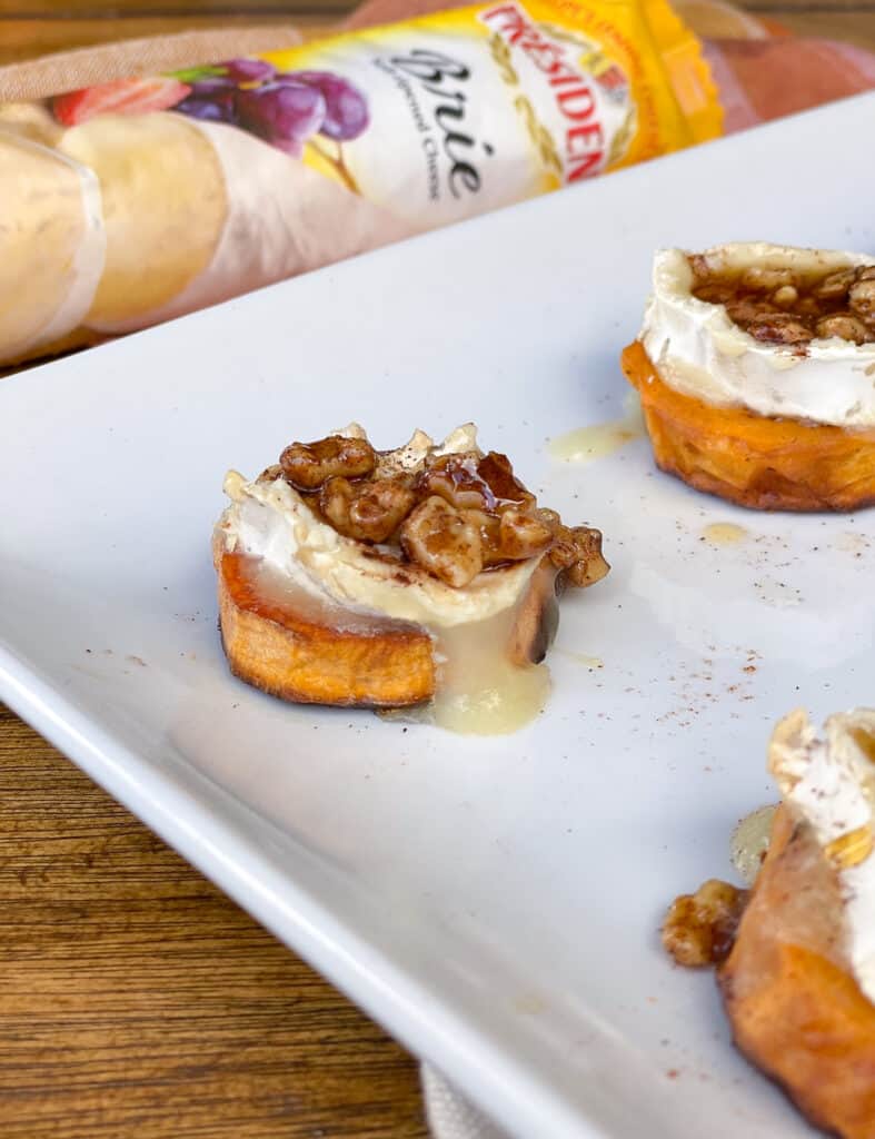 closeup of sweet potato round on plate and brie cheese dripping down