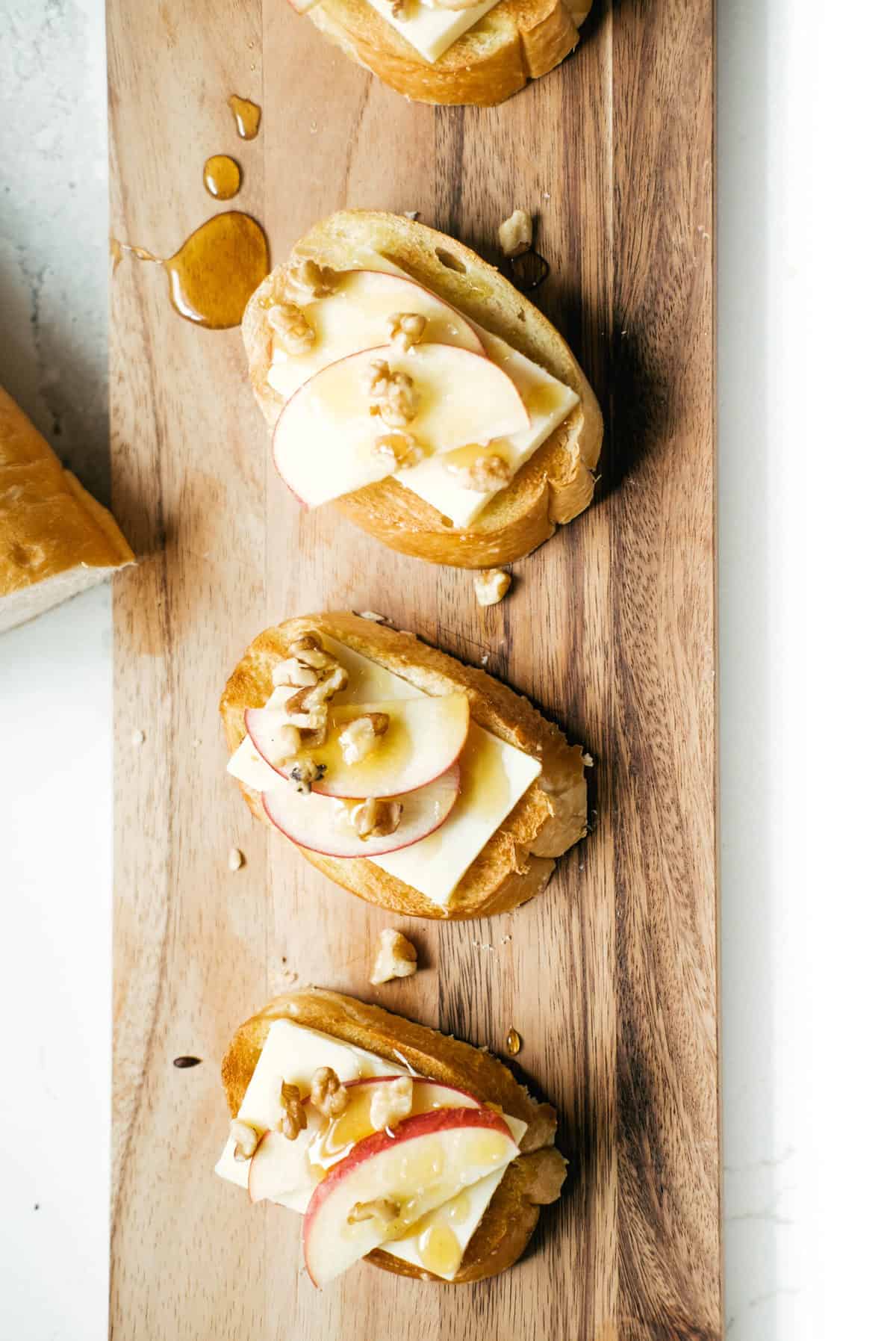 apple honey walnut crostini recipe on a cutting board.