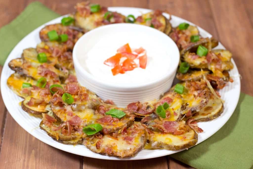 irish potato nachos on a white plate with sour cream.