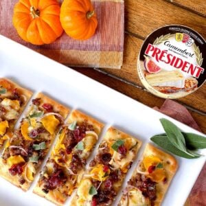 sausage and pumpkin flatbread appetizer on plate with sage