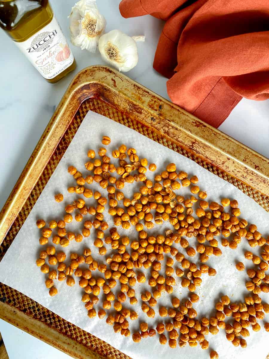 roasted spicy chickpeas on a baking sheet with garlic