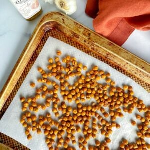 roasted chickpeas on a baking sheet with parchment paper