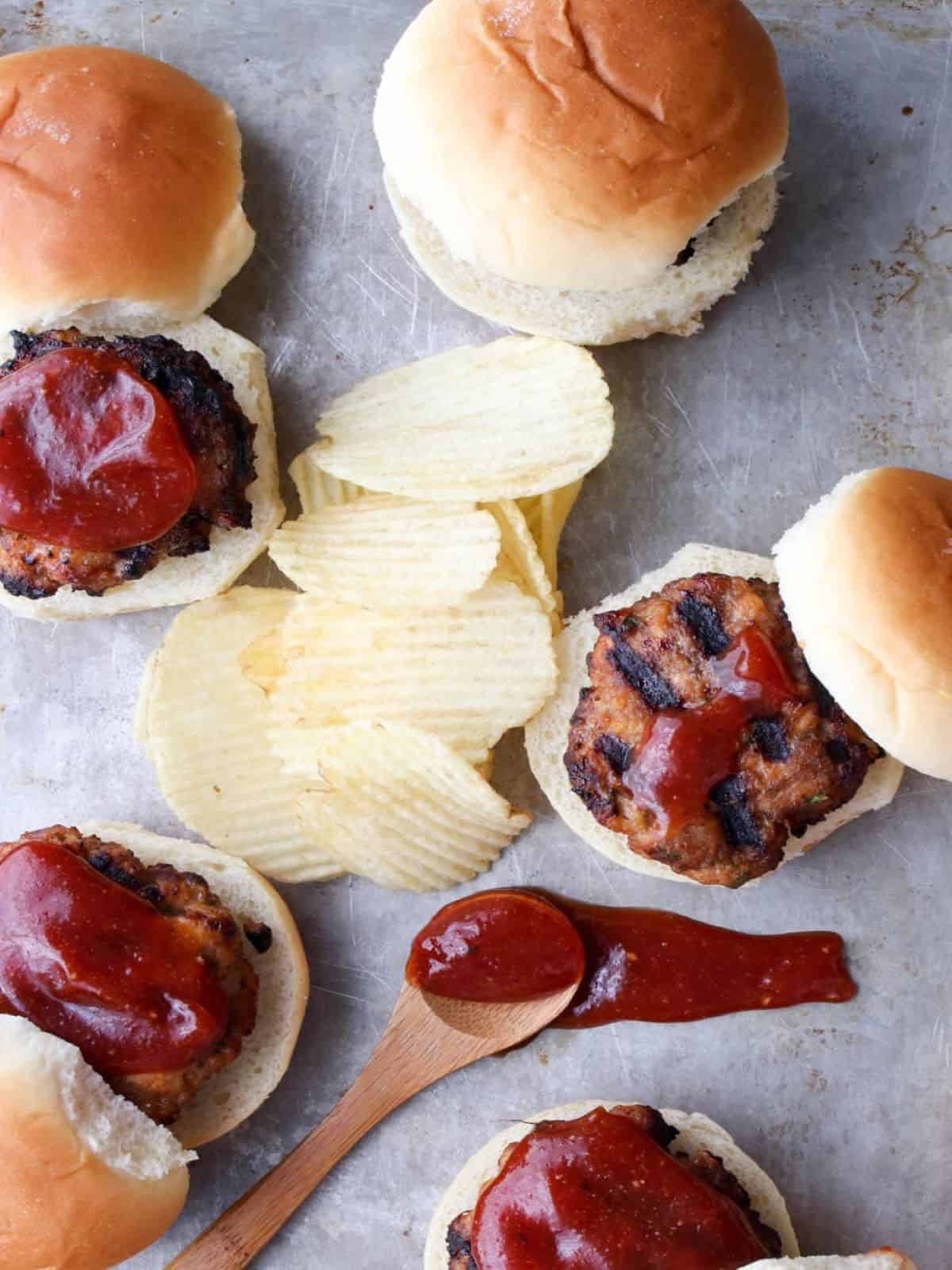 mini meatloaf sliders on a table with chips.