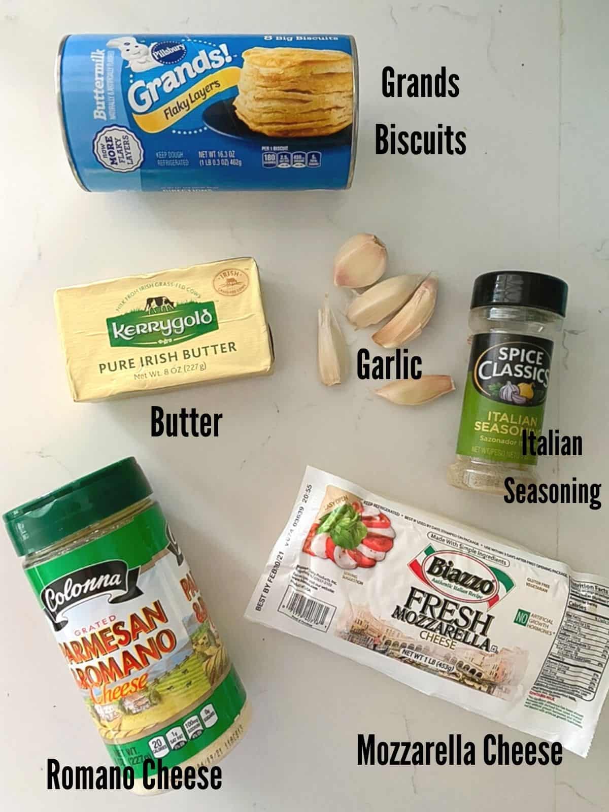 Ingredients to make cheesy stuffed garlic biscuit bombs laid out on table.