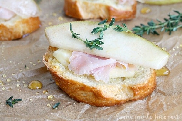 ham havarti and pear crostini with thyme leaves.