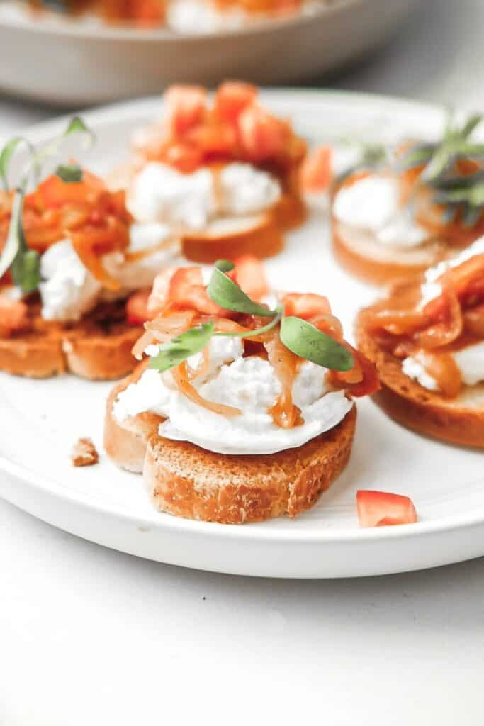 crostini with burrata and tomatoes on plate.