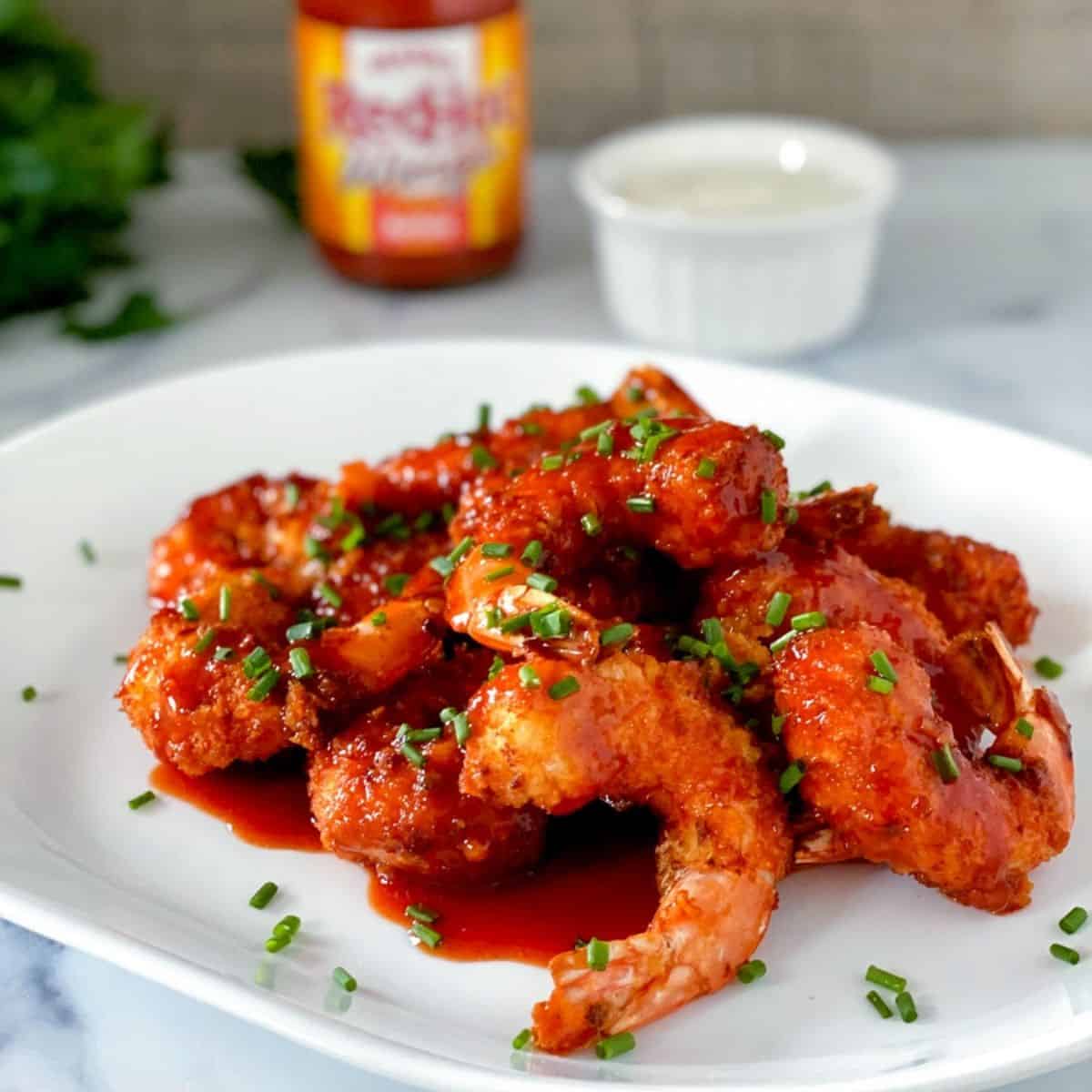 air fryer breaded buffalo shrimp on a plate.