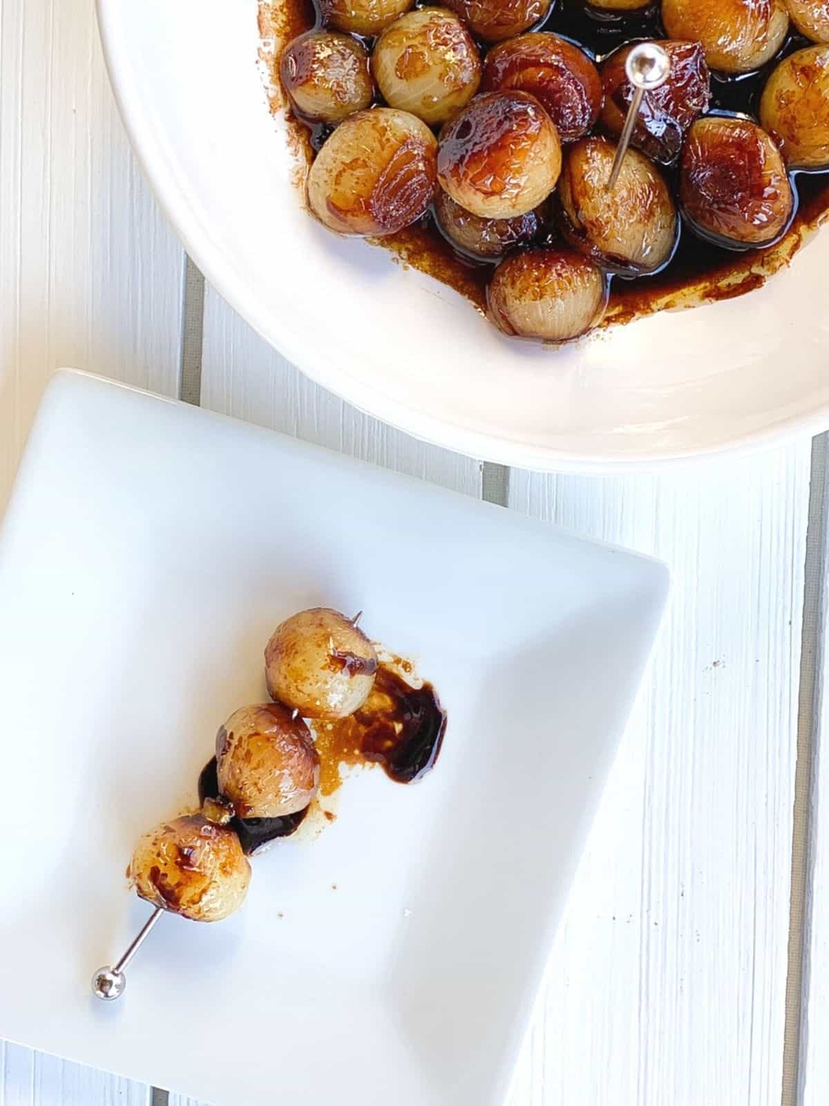 caramelized pearl onions on a plate with balsamic vinegar.