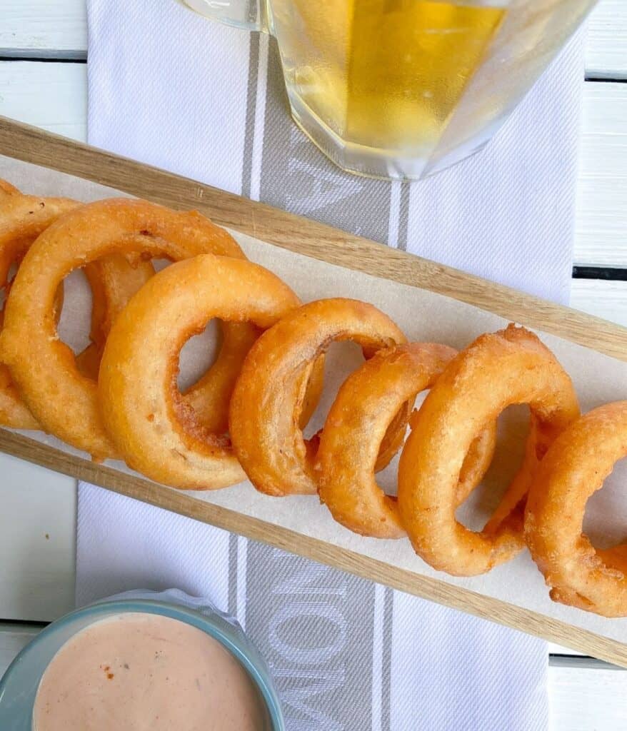 beer battered onion rings on cutting board.