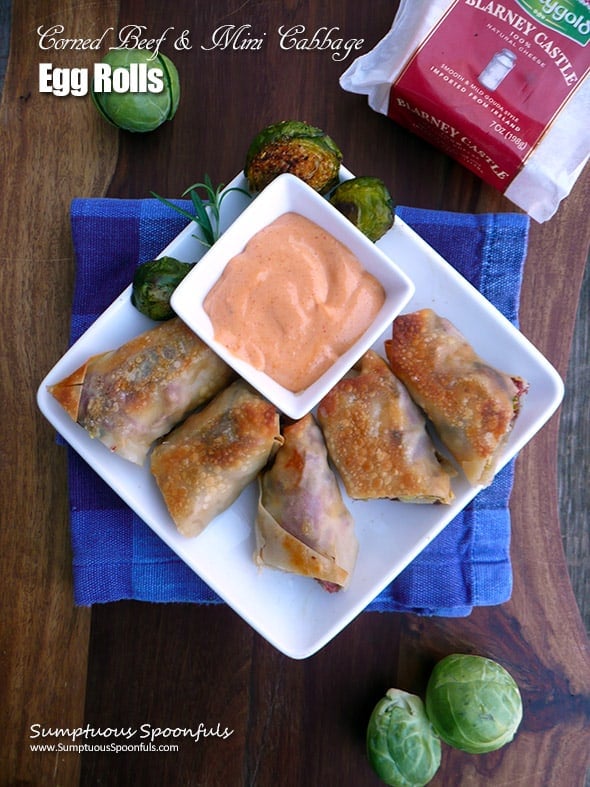 A plate of corned beef ande cabbage egg rolls with sauce.