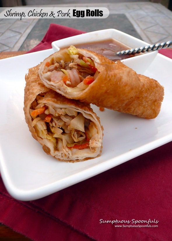 Egg roll cut in half on a square white plate with sauce.
