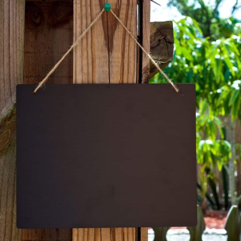 Chalkboard hanging at an outdoor party.