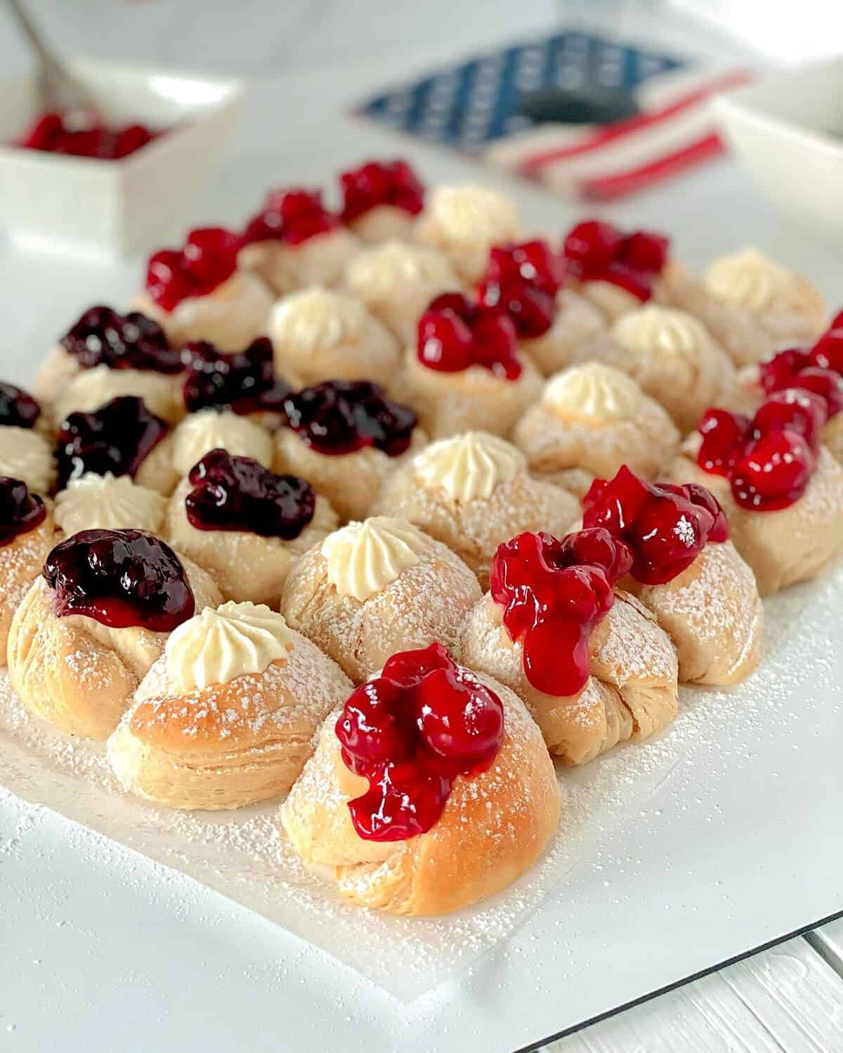 Red white and blue flag biscuits on a table topped with pie filling.