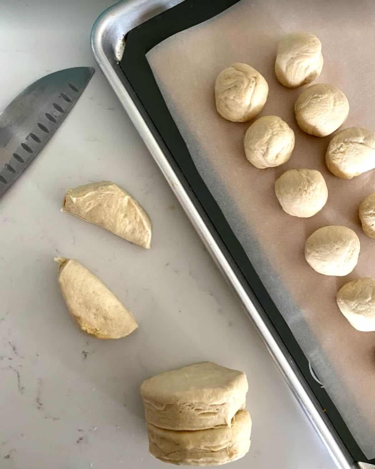 Biscuit dough in half rolled into balls.