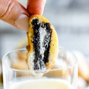Dipping a deep fried Oreo into a glass of milk
