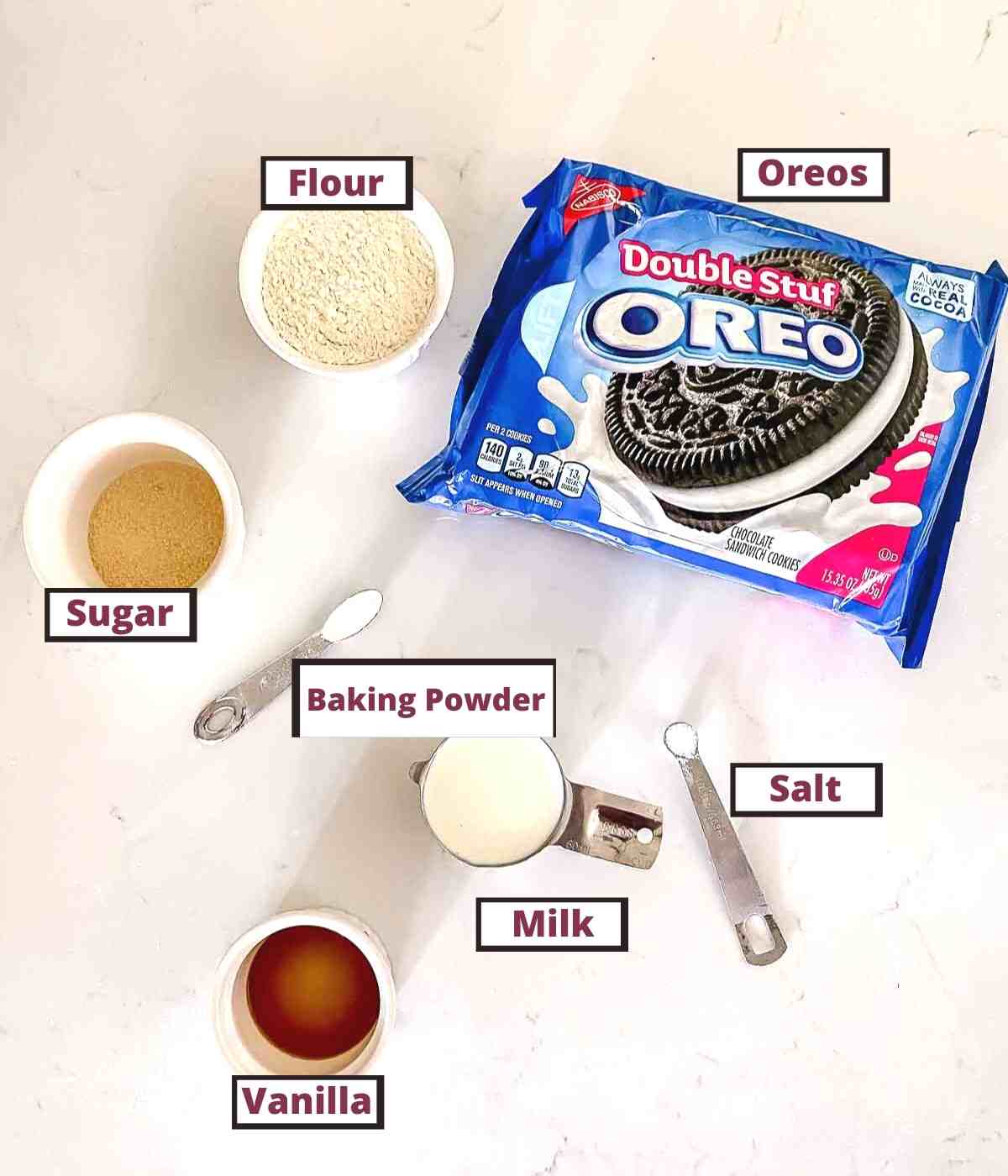 Oreos, flour, sugar, baking powder, milk salt and vanilla on a table to make fried Oreos.