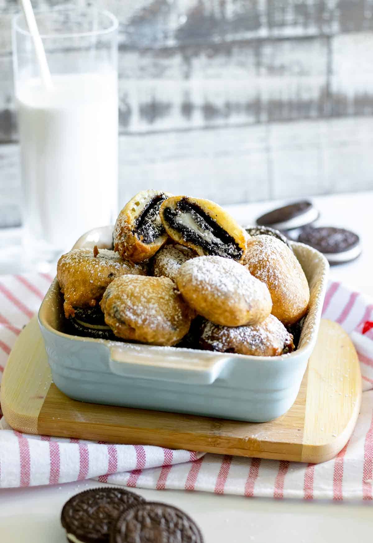 Deep fried oreos dessert in a blue with powdered sugar.