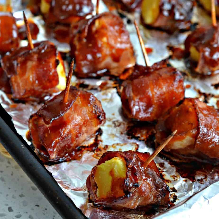 Bacon wrapped pineapple on a foil lined baking sheet.