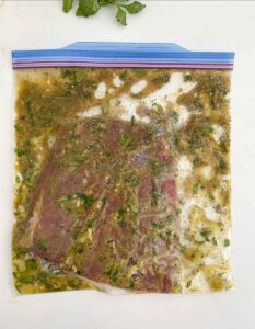 Steak with mixture in a resealable bag.