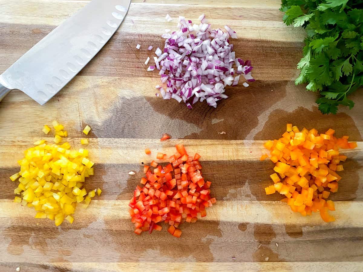 Diced peppers and onions on cutting board.