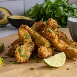 Close up of air fryer avocado fries with lime wedge.