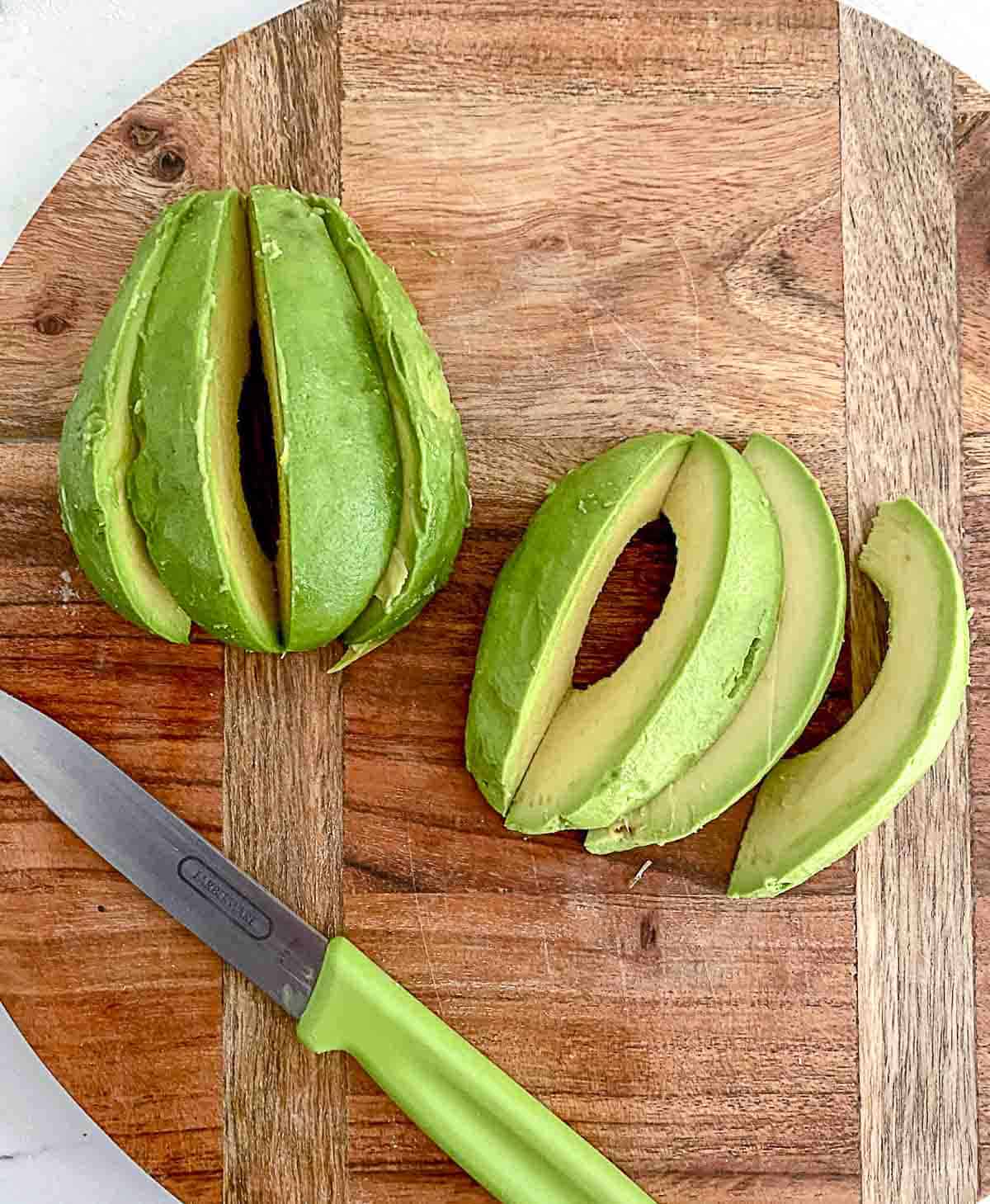 Avocado sliced on cutting board.