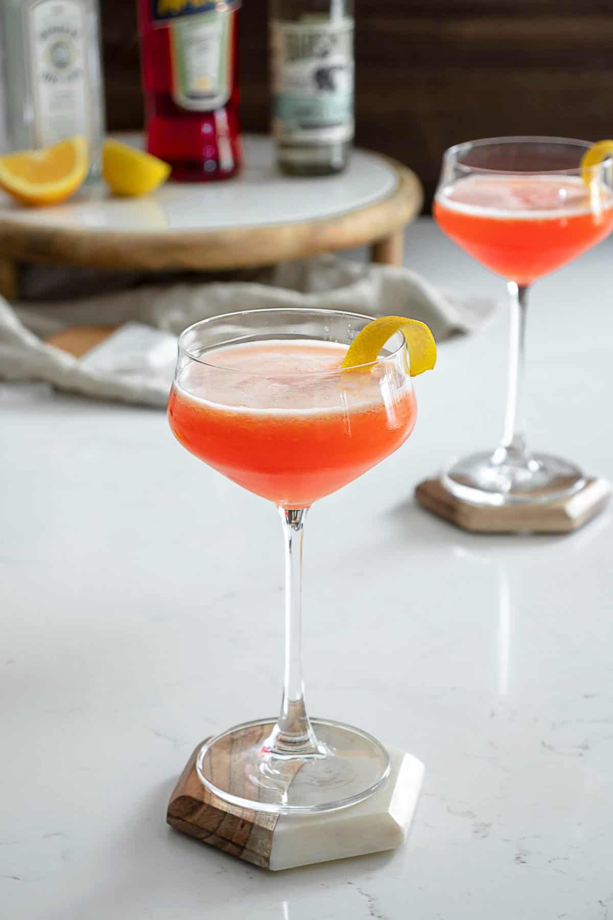 Aperol gin sour on table with lemon peel.