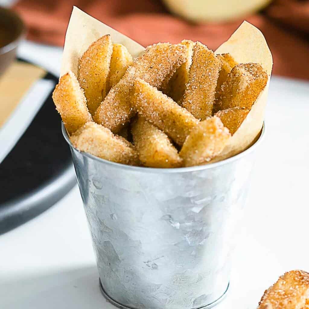 Deep fried apple fries in a tin cup.