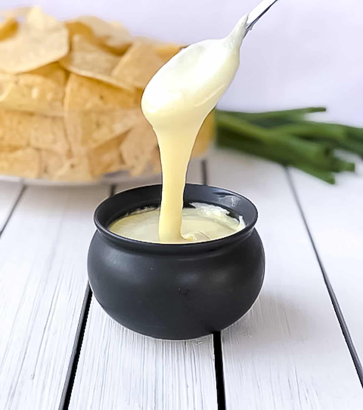 Spoon being dipped into flourless white cheese sauce.