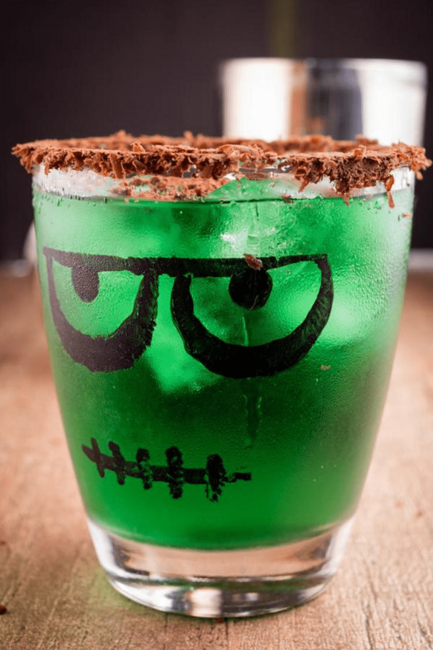Green halloween cocktail with chocolate rim in Frankenstein glass.