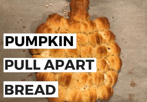 Bread shaped into a pumpkin and baked on baking sheet.