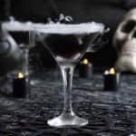 Black vodka martini for halloween with spooky dry ice smoke effect.