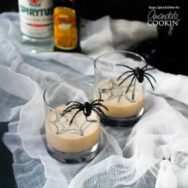 Spider cocktail with spiders on cocktail glass on table.