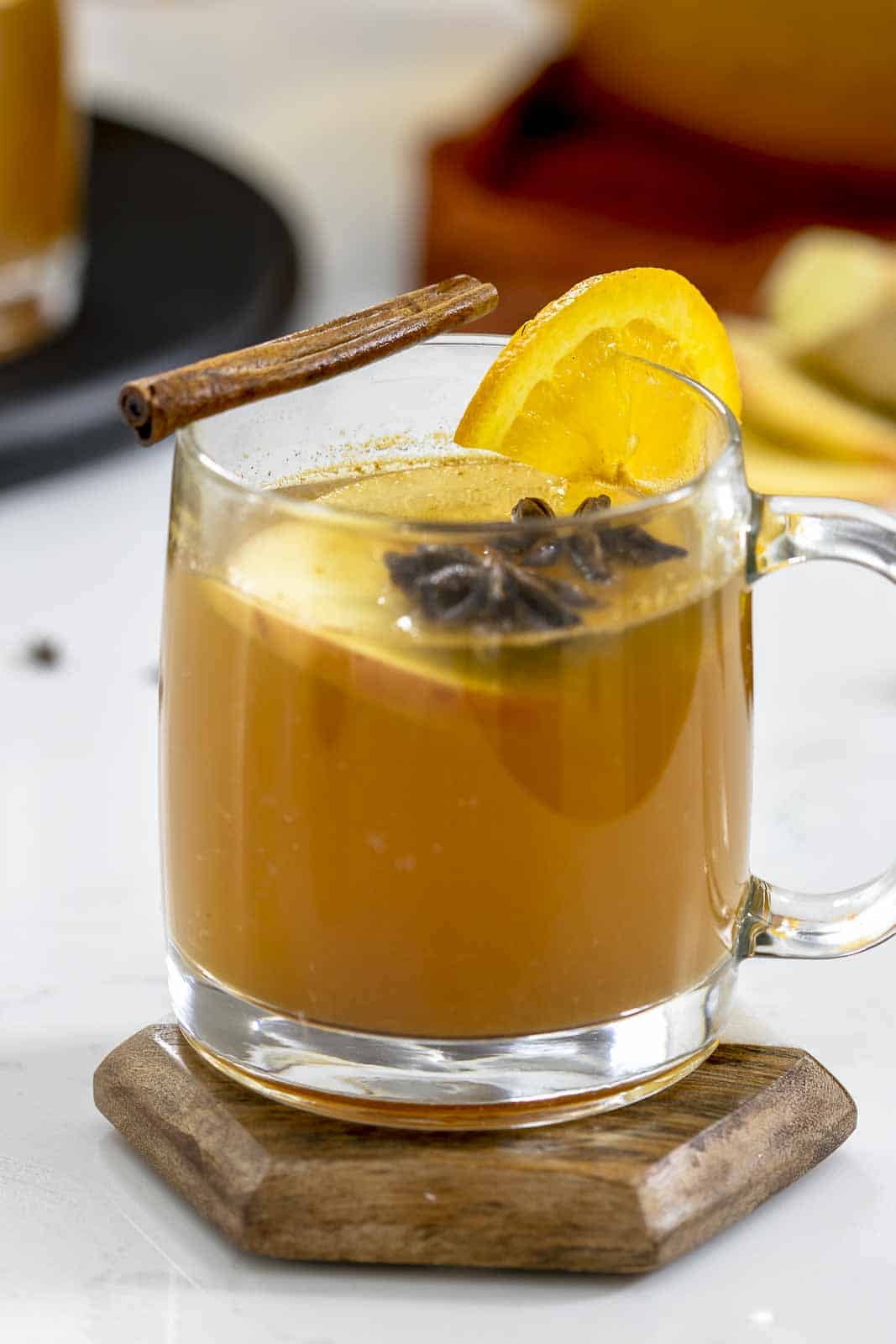 Hot mulled spiked apple cider in a clear mug.
