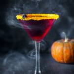 Halloween cocktail with orange rim and spider.