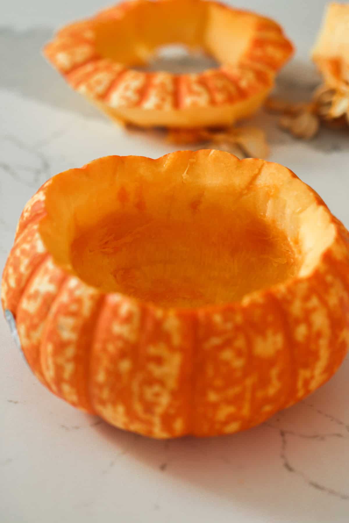 A pumpkin with the center hollowed out to use as a bowl.