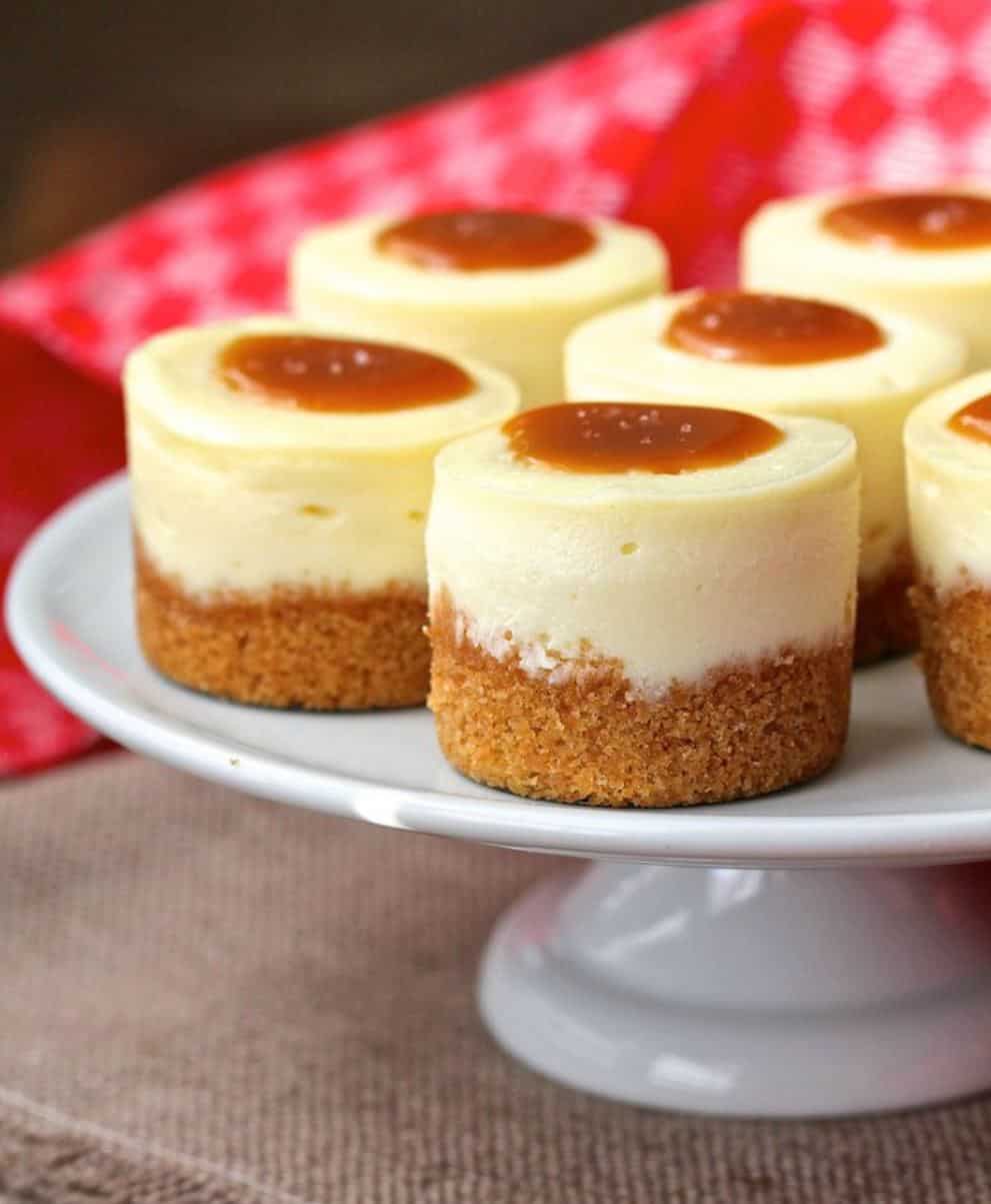 Mini cheesecakes with graham base on a cake plate. 