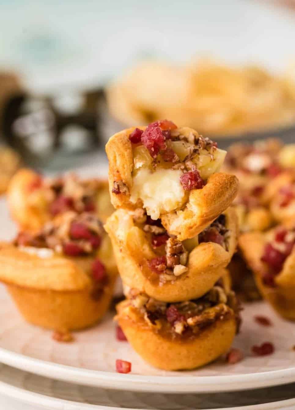 Brie cups with bacon bits on a white plate.